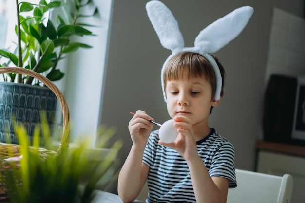 Mignon petit garçon à colorier des oeufs pour Pâques Image avec mise au point sélective