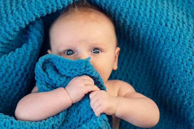 Un mignon petit garçon étreignant une douce couverture bleue