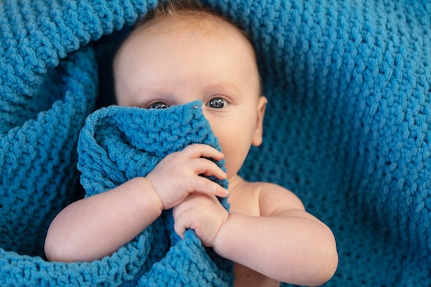 Un mignon petit garçon étreignant une douce couverture bleue