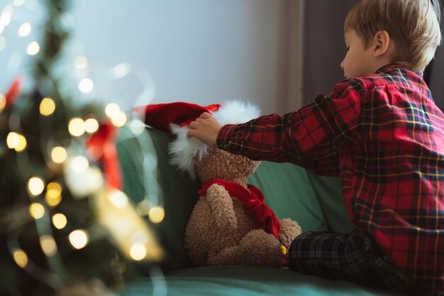 Mignon petit garçon habillant l'ours en peluche