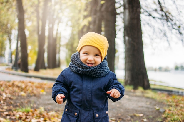 Mignon petit garçon heureux dans des vêtements décontractés à la mode en automne parc naturel