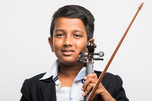 Mignon petit garçon indien ou asiatique jouant du violon comme un professionnel, isolé sur fond blanc