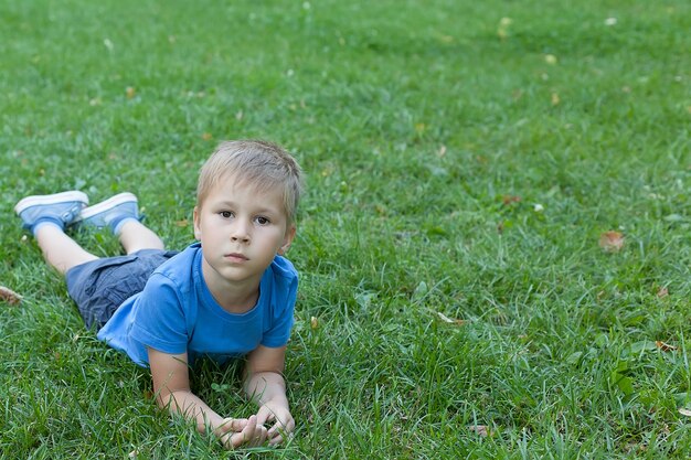 Mignon petit garçon jouant dans le parc verdoyant