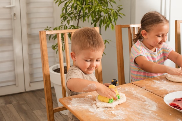 Le mignon petit garçon joue en cuisinant