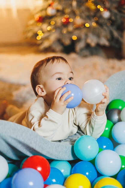 Un mignon petit garçon joue dans une piscine de balles en plastique piscine sèche pour enfants à la maison