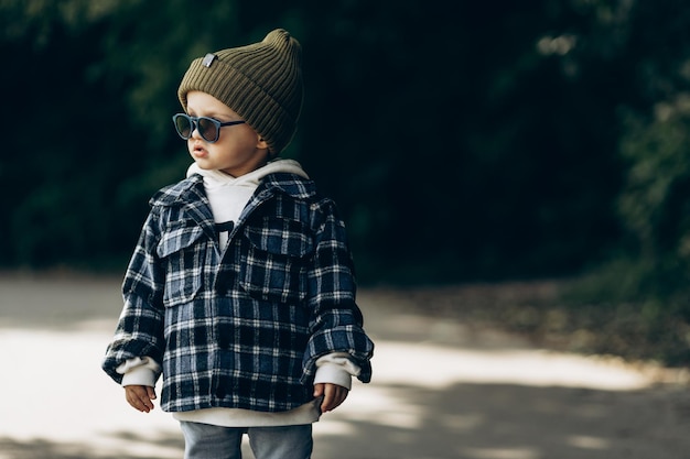 Mignon petit garçon marchant dans un parc en automne