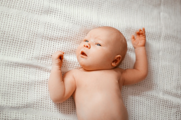 Mignon petit garçon nouveau-né allongé sur une couverture.