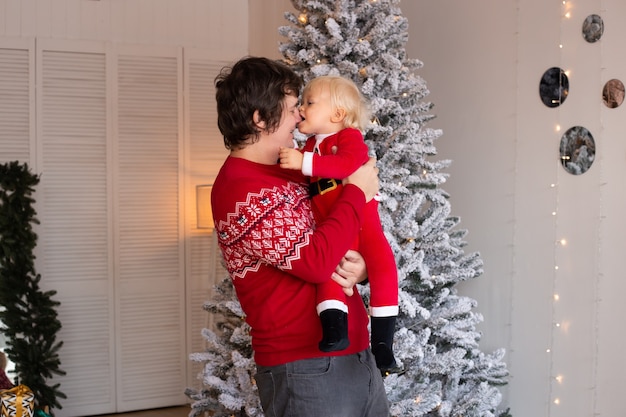 Mignon petit garçon et père près de l'arbre de Noël. Noel, vacances et concept d'enfance.