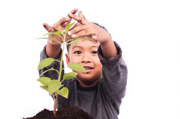 Photo mignon petit garçon planter un arbre