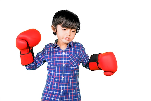 Mignon petit garçon porte des gants de boxe rouges en studio