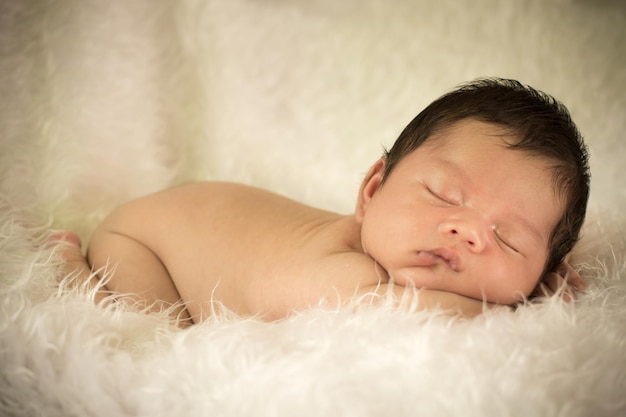 Un mignon petit garçon qui dort sur de la fourrure