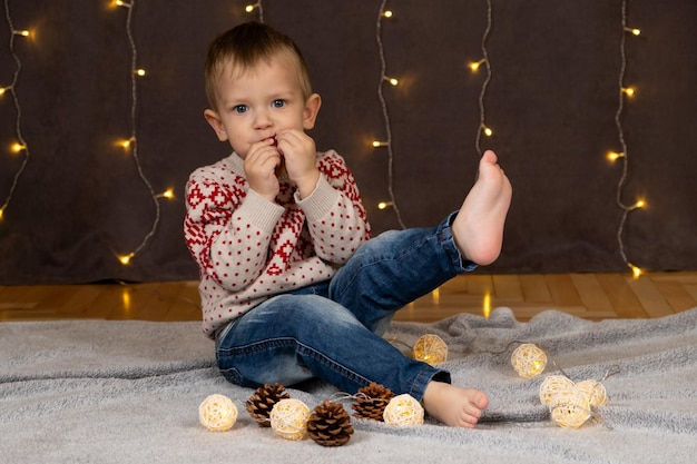 Un mignon petit garçon qui mange du pain d'épice pour Noël.