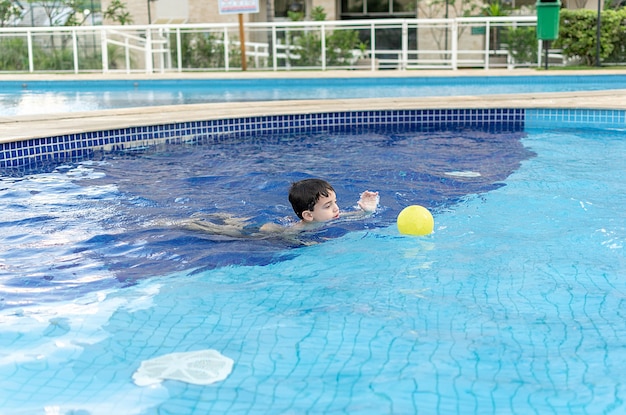 Mignon petit garçon se détendre à la piscine