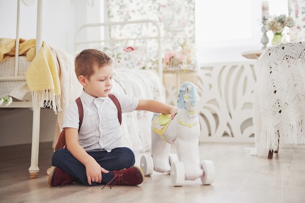 Mignon petit garçon se joue avec un cheval jouet