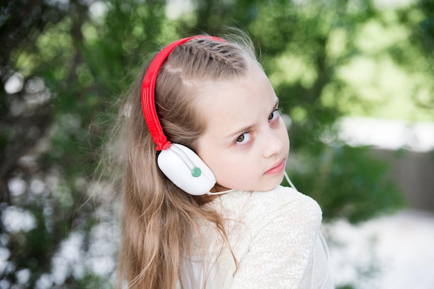 Mignonne petite fille appréciant la musique à l'aide d'écouteurs