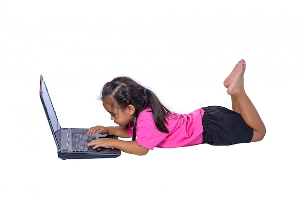 Mignonne petite fille asiatique fille allongée sur le sol à étudier ou à l'aide d'un ordinateur portable isolé sur fond blanc