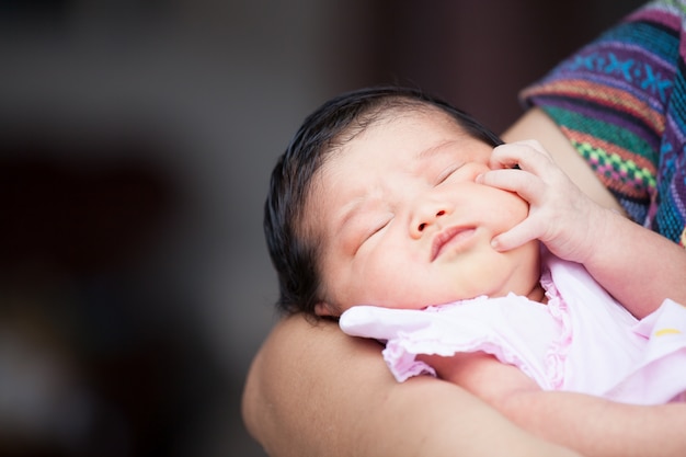 Mignonne petite fille asiatique nouveau-né dormant sur le bras de la mère