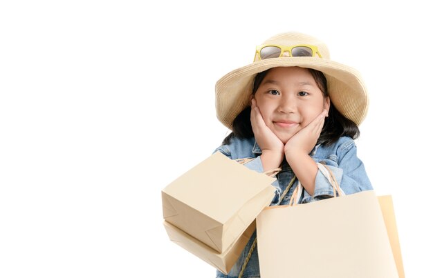 Mignonne petite fille asiatique tenant des sacs à provisions.