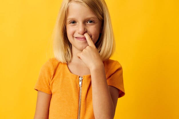 Mignonne petite fille aux cheveux blonds à base de fond jaune de l'enfance