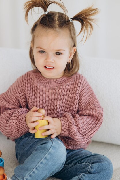 Mignonne petite fille en bas âge jouant à la maison avec des jouets en bois écologiques Heureux enfant coupant des légumes et des fruits avec un couteau jouet L'enfant jouant à des jeux éducatifs