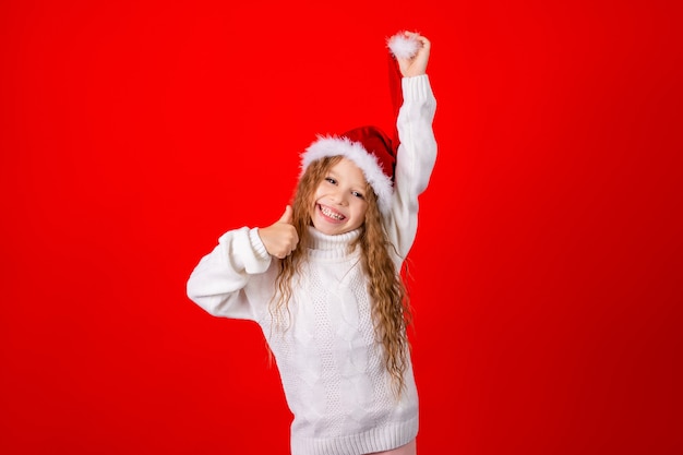 Mignonne petite fille avec chapeau du père Noël et un pull