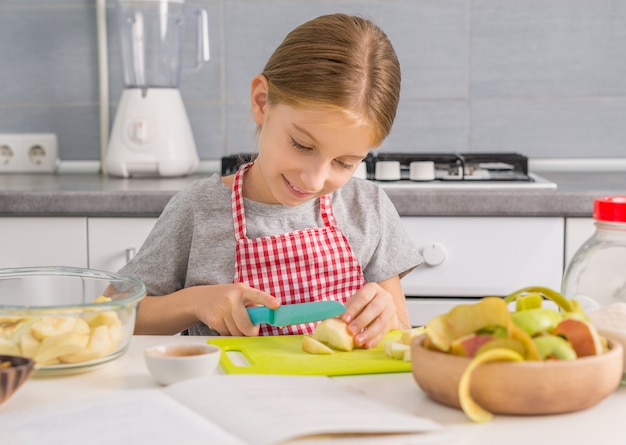 Mignonne petite fille, couper des pommes pour strudel