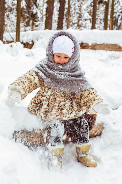 Mignonne petite fille dans des vêtements chauds en hiver