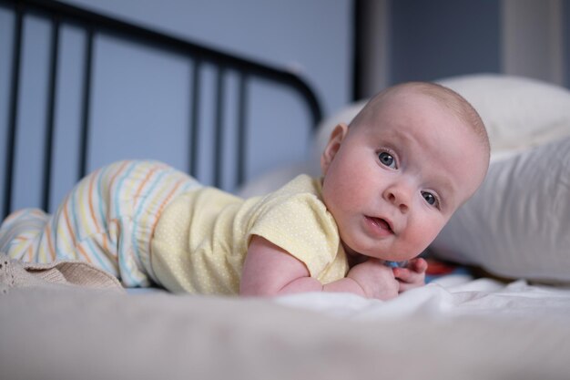 Mignonne petite fille du mois heureux en couche couchée et jouant