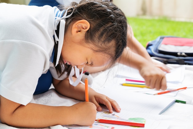 mignonne petite fille écrit la décision du livre de leçons