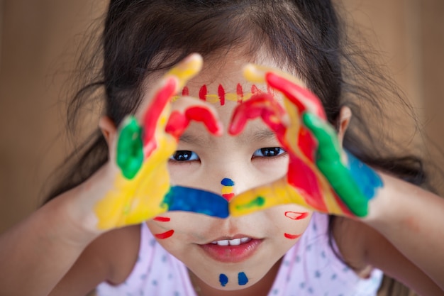 Mignonne petite fille enfant asiatique avec des mains peintes faire la forme de coeur coloré avec plaisir et amour