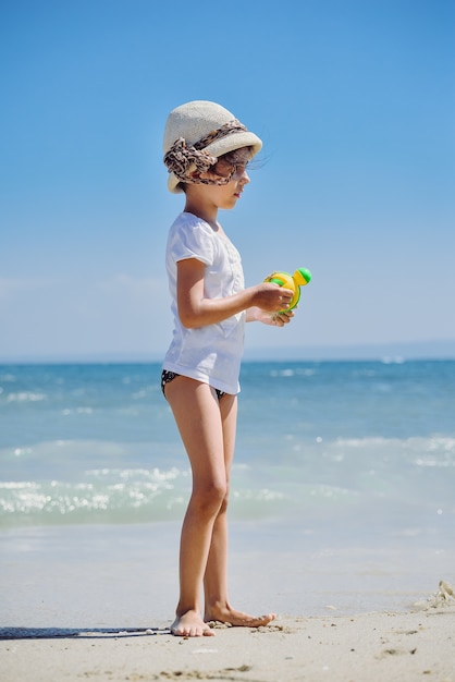 Mignonne petite fille jouant sur la plage