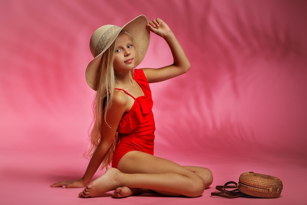 Mignonne petite fille en maillot de bain rouge posant