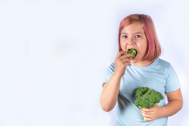 Mignonne petite fille mange du brocoli