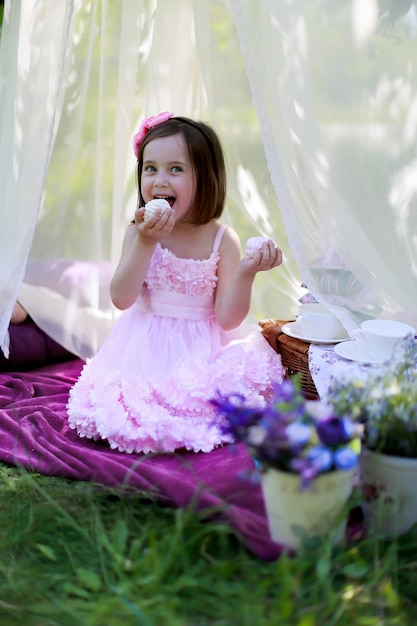 Mignonne petite fille mangeant des guimauves dans la nature