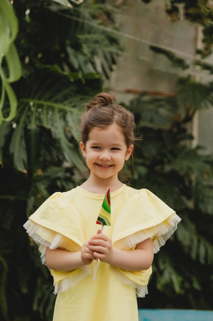 Mignonne petite fille mangeant une sucette en forme de pastèque Enfant avec des sucettes dans le jardin botanique