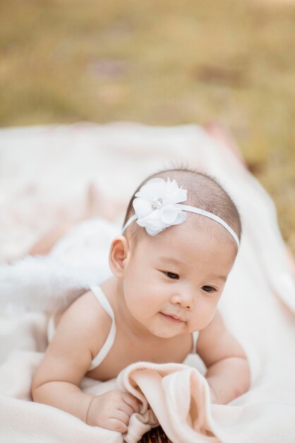 Une mignonne petite fille portant une aile de costume en couchant sur une couverture