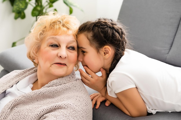 mignonne petite-fille rendant visite à sa grand-mère à la maison.