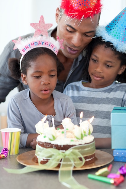 Mignonne petite fille et sa famille célébrant son anniversaire