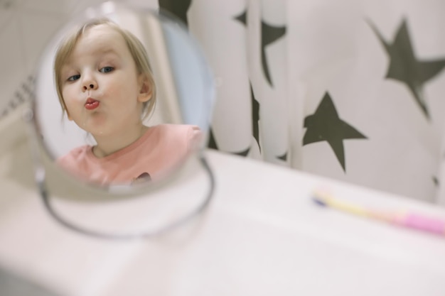 Mignonne petite fille se brosser les dents dans la salle de bain Nettoyage des dents soins dentaires