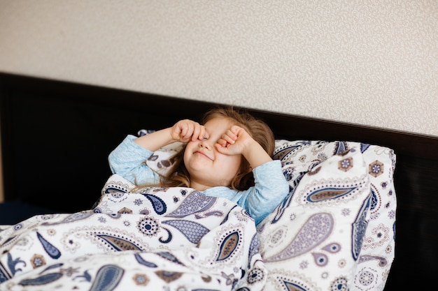 Mignonne petite fille se réveillant le matin