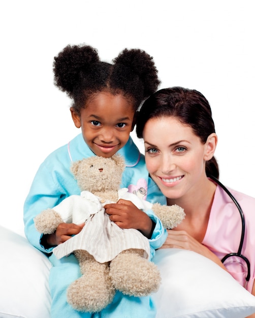 Mignonne petite fille avec son médecin souriant à la caméra