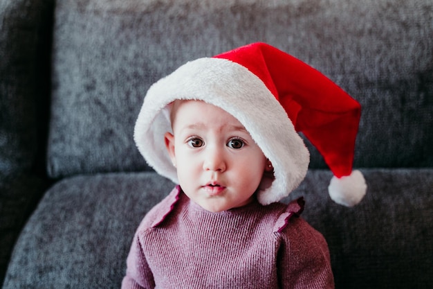 Une mignonne petite fille souriante assise sur le canapé à la maison.