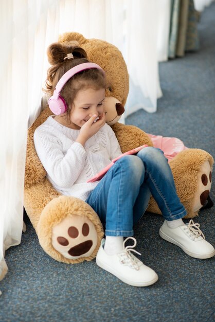 Mignonne petite fille tenant une tablette dans ses mains Elle est dans un casque