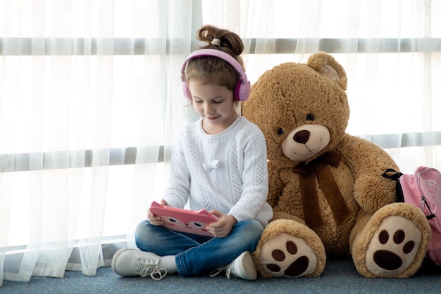 Mignonne petite fille tenant une tablette dans ses mains Jeux Les enfants utilisent la technologie