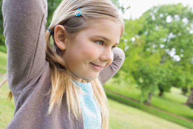 Mignonne souriante jeune fille au parc