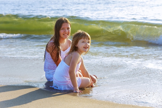 Mignonnes petites filles jouant ensemble à la plage pendant les vacances d&#39;été