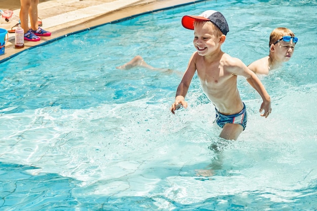 De mignons frères aiment nager dans la piscine du territoire de l'hôtel