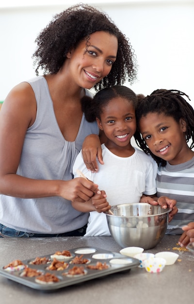 Mignons frères et soeurs avec leur mère en train de préparer des biscuits