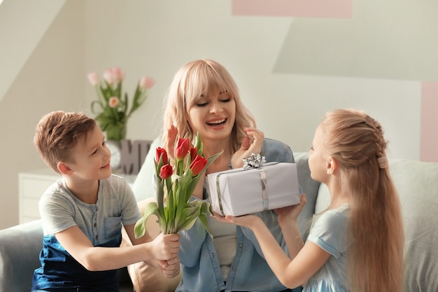 Mignons petits enfants félicitant leur mère à la maison