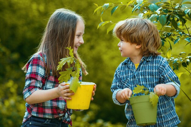 Mignons petits enfants profitant du concept d'écologie de la ferme enfant jardinant avec des enfants
